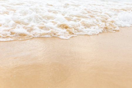 Beach sand sea water summer background. Sand beach desert texture. White foam wave sandy seashore top view.の写真素材
