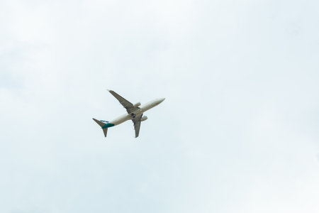 White passenger airplane flying in the sky amazing clouds in the background - Travel by air transport.の写真素材