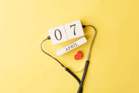 Stethoscope, red heart and 7th April calendar on yellow background. Healthcare, life Insurance, world Health day concept.の写真素材