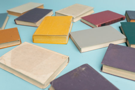 Old books on light blue table, top view. World Book Day background.