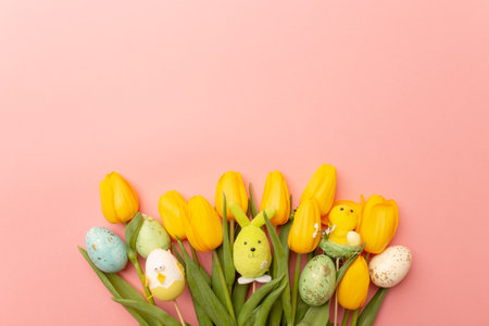 Yellow tulips and easter decor on a pink background, top view, spring bouquet. Copy spaceの写真素材