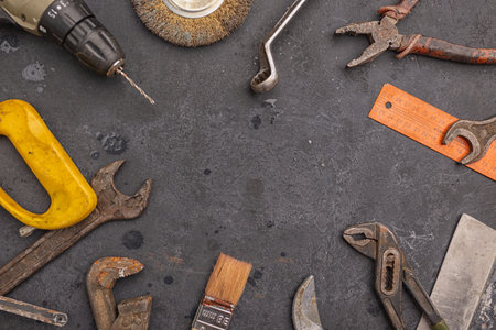 Labour day background concept - different construction tools on dark stone background with copy...