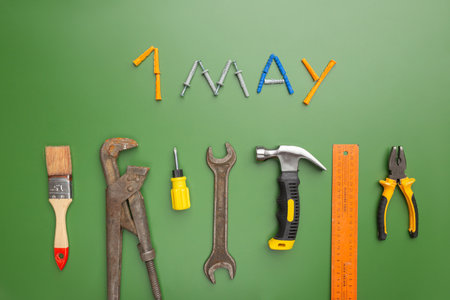 International Workers Solidarity Day, 1 May concept. Different construction tools on green background with text 1 mayの写真素材