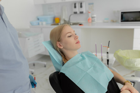 Portrait of a woman sitting at the dental chair on the background at the dental officeの写真素材