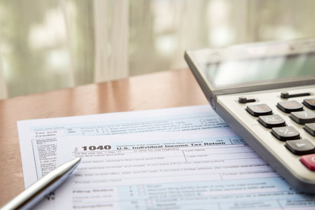 Form 1040, U.S. Individual income tax return place on table with calculator and pen