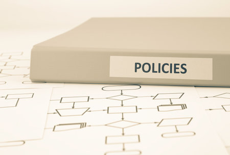 Business document binder with POLICIES word on label place on blank process procedure flow charts, sepia tone imageの写真素材