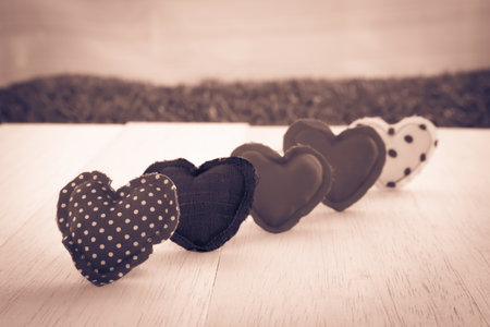 Group of hearts handmade crafts from cotton and silk cloth stack on wood background, sepia tone  and retro style, love and valentineの写真素材