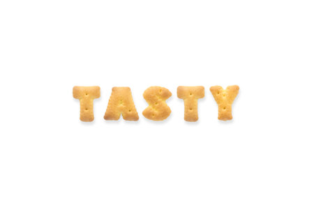 Collage of the capital letters word TASTY. Alphabet cookie biscuits isolated on white backgroundの写真素材