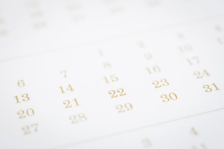 Selective focus on days and dates of calendar page. Closeup timetable shown mix dot prints for gold color. Modern schedule background clean minimal style. Project planning, appointment concepts.の写真素材