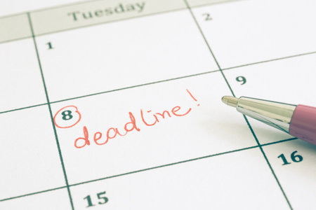 Closeup planner calendar and pen, vintage tone. Focus on the red wordÂ Deadline written on...