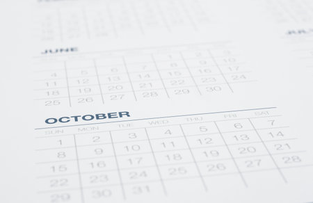 Closeup calendar page focus on October, blurred the months pass, weekly start on sunday. Clean blue tone background with modern minimal style. Business vision, mission, timetable, year end review.の写真素材