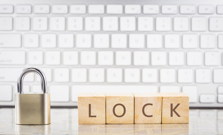 Close keypad with word LOCK on wooden cubes, white keyboard on background. Encryption, internet connection, cyber security, system login, information privacy, database management concepts.の写真素材
