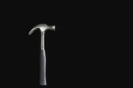 Closeup view of a steel hammer on a black backgroundの写真素材