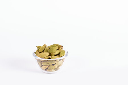 Glass bowl with Indian green cardamom on a white backgroundの写真素材