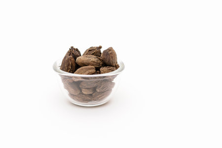 Black cardamom in a glass bowl on a white backgroundの写真素材