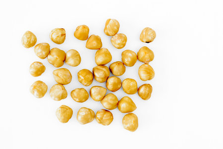 Handful of shelled hazelnuts on a white backgroundの写真素材