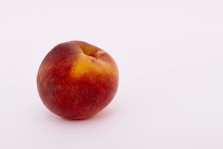 Single ripe peach fruit on a white backgroundの写真素材