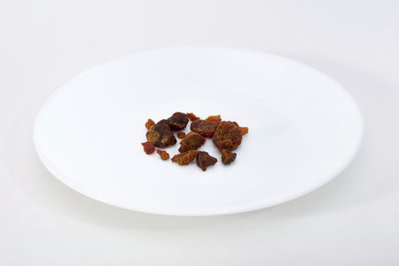 Asafoetida pices on a white plate on a white backgroundの写真素材