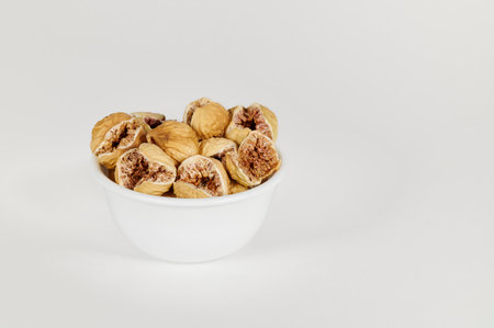 Closeup view of a bowl of dried figs on a white backgroundの写真素材