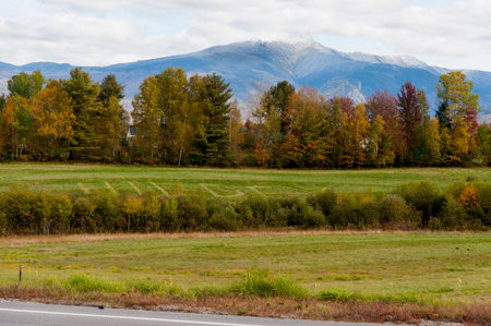 NEW HAMPSHIRE - SEPTEMBER 30, 2009: Green filed with name cut into grass beneath mountain with fresh snowの写真素材