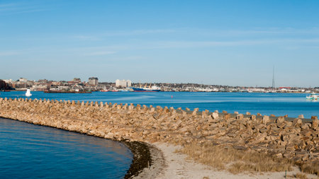FAIRHAVEN, MASSACHUSETTS - JANUARY 12, 2016: Palmer's Island lighthouse and docked freighter on calm winter day in New Bedford harborのeditorial素材