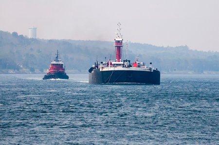 CAPE COD CANAL, MASSACHUSETTS/USA - JULY 4, 2006: Tug and vessel identified on  Bouchard Transportation Co.  web site as double-hulled oil barge passing through Cape Cod Canalのeditorial素材