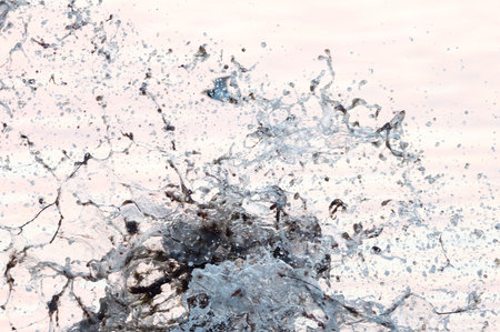 Wave crashing against rock creates eruption of surf and seaweedの写真素材