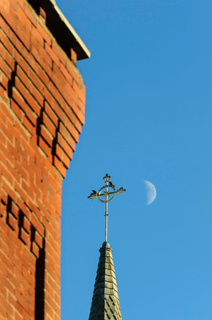 Brick chimney steeple and moon in afternoon alignmentの写真素材