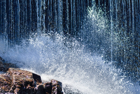 Cascading water smashes over rocky base