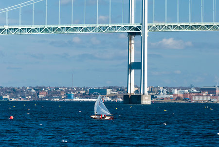 Jamestown, Rhode Island, USA - January 13, 2008: Small sailboat cuts across Narragansett Bay near Newport Bridgeのeditorial素材