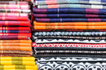 Ordered stacks of brightly colored woolen scarvesの写真素材