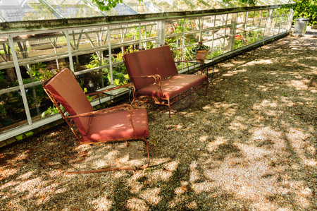 New Bedford, Massachusetts, USA - May 25, 2016: Retro lawn chairs under tree offer reminder of earlier times at Allen C. Haskell Public Gardensのeditorial素材