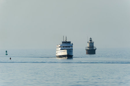 New Bedford, Massachusetts, USA - April 12, 2017: Block Island ferry M.V. Carol Jean passing Butlers Flat lighthouse in New Bedford harbor on hazy morningのeditorial素材