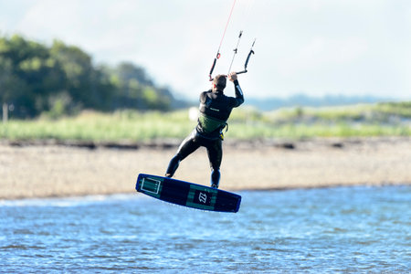 Fairhaven, Massachusetts, USA - June 26, 2017: Kiteboarder mid-jump off Buzzards Bay beach