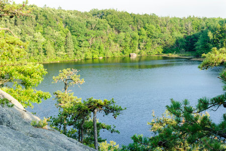 Steep granite hillside dropping to Long Pond in Hopkinton, Rhode Islandの写真素材