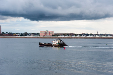 New Bedford, Massachusetts, USA - September 30, 2017: Fishing vessel Wando River leaving New Bedford harbor under stormy skiesのeditorial素材