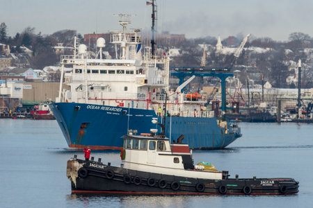New Bedford, Massachusetts, USA - December 15, 2017: Tug Jaguar and research vessel Ocean Researcher on Acushnet River with New Bedford backdropのeditorial素材