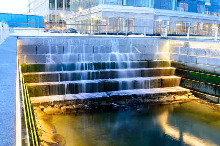 Water cascading down tiers in tidal well along Harborwalk in South Bostonのeditorial素材