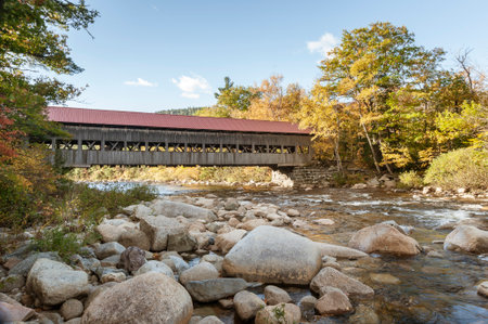 Swift River flowing past Albany Covered Bridge on sunny autumn morning