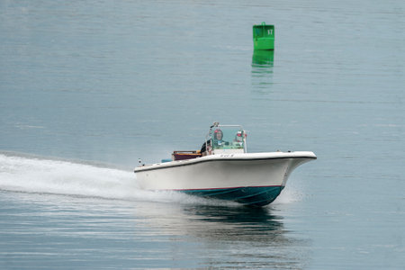 New Bedford, Massachusetts, USA - May 1, 2019: Powerboat cruising across calm Acushnet River with...