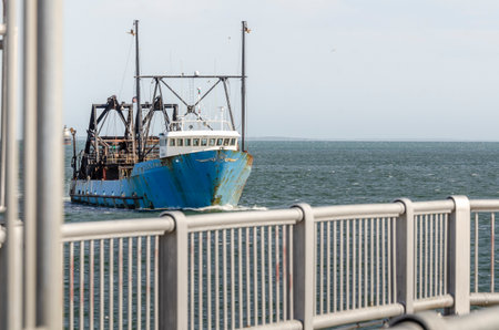 New Bedford, Massachusetts, USA - June 4, 2019: Commercial fishing vessel E.S.S. Pride framed by...