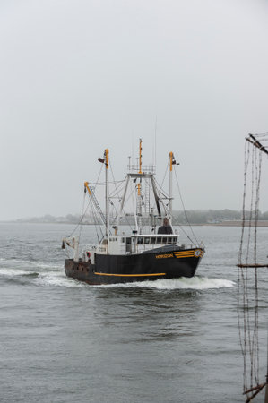 New Bedford, Massachusetts, USA - July 12, 2019: Commercial fishing vessel Horizon approaching hurricane protection barrier on foggy morningのeditorial素材