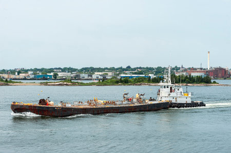 New Bedford, Massachusetts, USA - July 11, 2019: Tug Thuban pushing fuel barge Meropa 900 out of New...