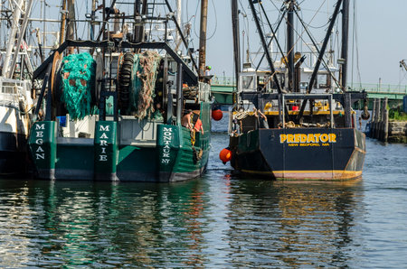 New Bedford, Massachusetts, USA - July 13, 2019: Crewman aboard commercial fishing vessel Predator...