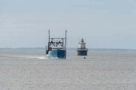 New Bedford, Massachusetts, USA - May 8, 2019: Clammer E.S.S. Pride passing Butler's Flat Light Station on return to New Bedford from fishing tripのeditorial素材