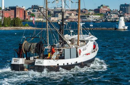 New Bedford, Massachusetts, USA - May 21, 2019: Commercial fishing vessel Rebecca Mary, hailing port South Kingstown, Rhode Island, crossing New Bedford inner harbor with lighthouse aheadのeditorial素材