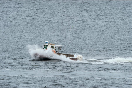 New Bedford, Massachusetts, USA - May 13, 2019: Lobster boat blasting through wake on its way across New Bedford outer harborのeditorial素材