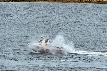 New Bedford, Massachusetts, USA - May 13, 2019: Lobster boat banging through wake on its way across...