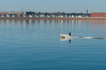 Fairhaven, Massachusetts, USA - March 20, 2019: Wet-suited diver driving center console boat toward Buzzards Bayのeditorial素材