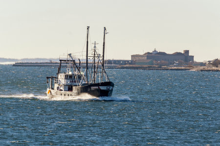 New Bedford, Massachusetts, USA - January 7, 2019: Eastern rig commercial fishing boat Leader, hailing port Cape May, New Jersey, sporting thin layer of ice as she heads into New Bedford on windy winter morningのeditorial素材